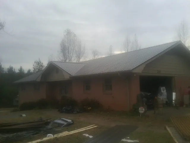 Gray metal roof on a stucco house with an attached garage in Naturita