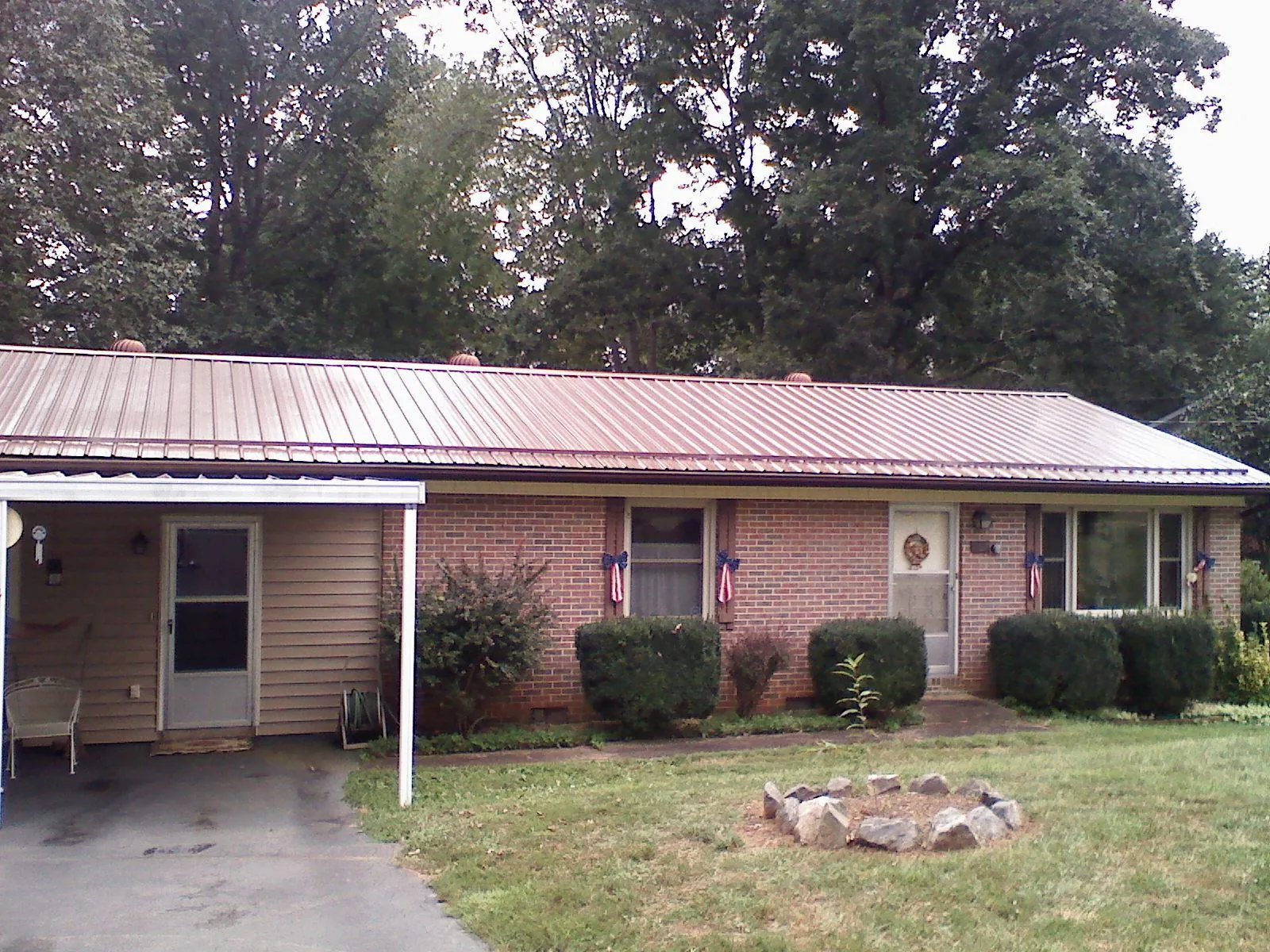Bronze metal roof and carport on a brick ranch home — Roof Repair work by our crew in Naturita